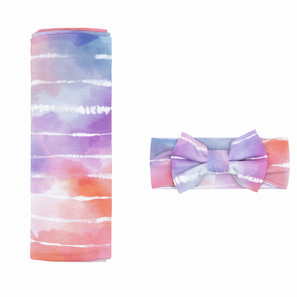 Flat lay image of a Pastel Tie Dye Dreams swaddle & luxe bow headband set