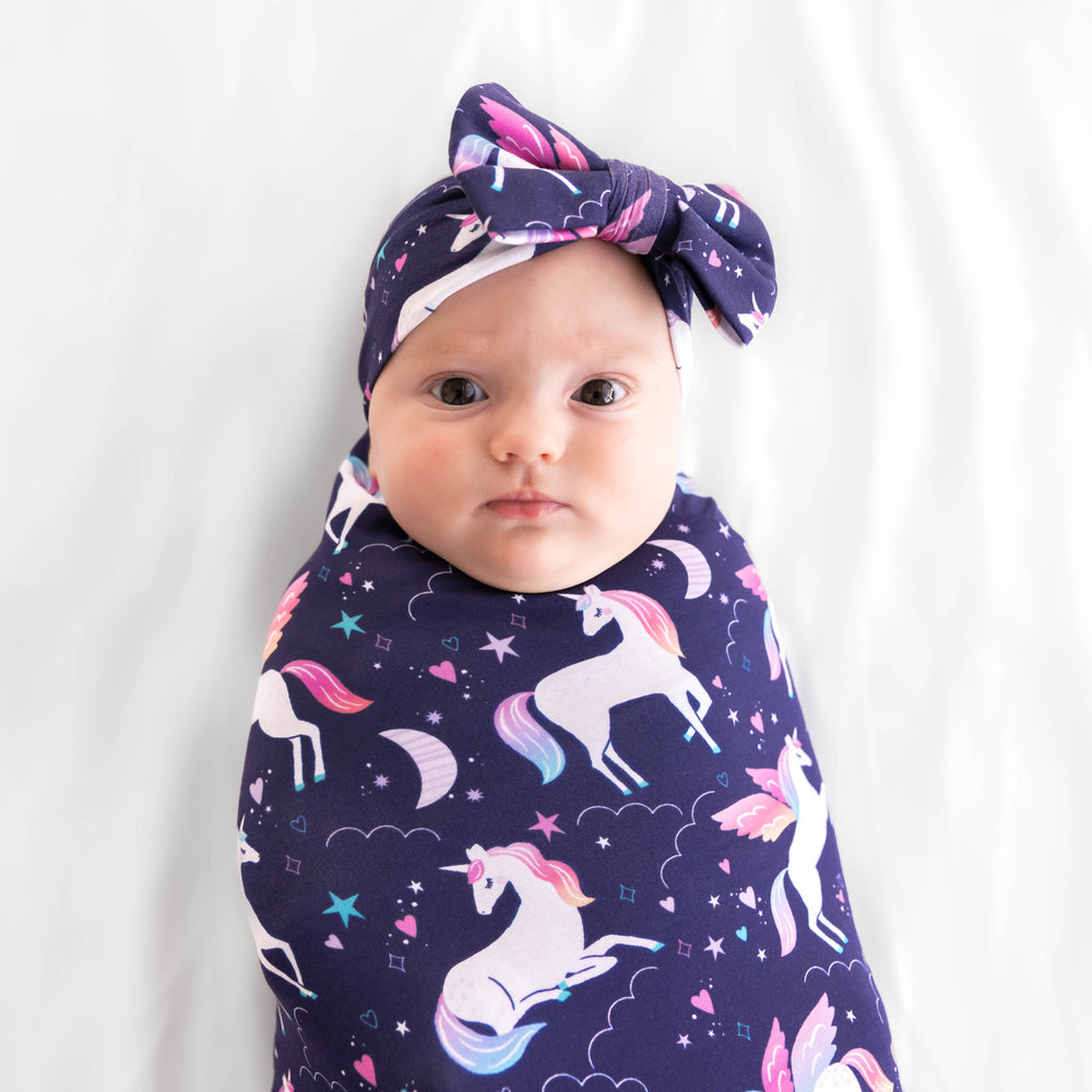 Close up image of baby wearing the Magical Skies Swaddle & Luxe Bow Headband Set