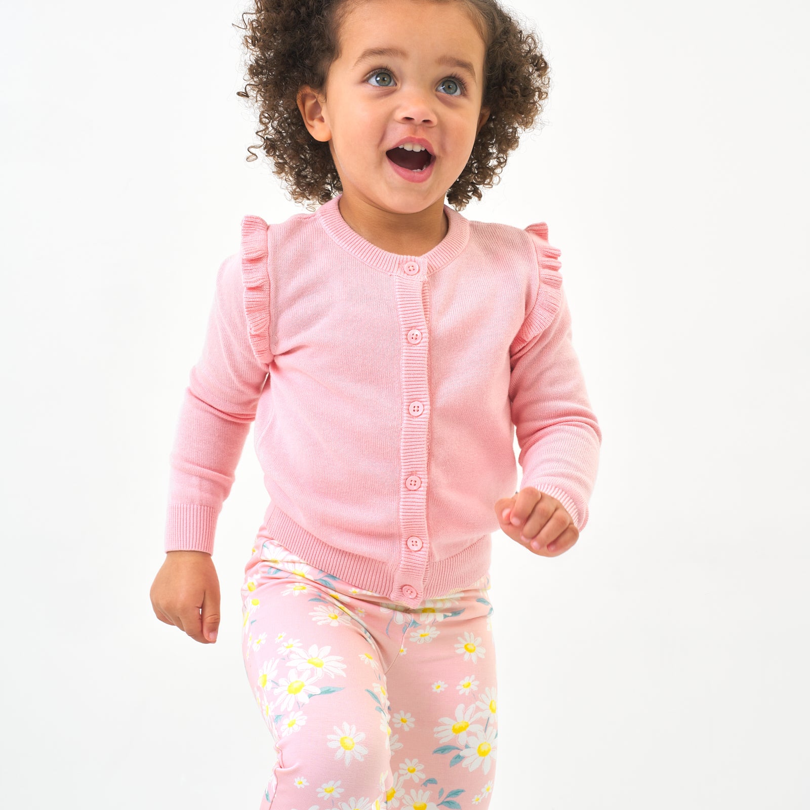 Child wearing a Pink Blossom ruffle cardigan and coordinating leggings