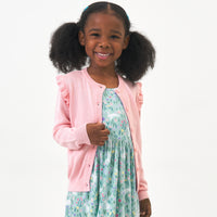 Child wearing a Pink Blossom ruffle cardigan and coordinating dress