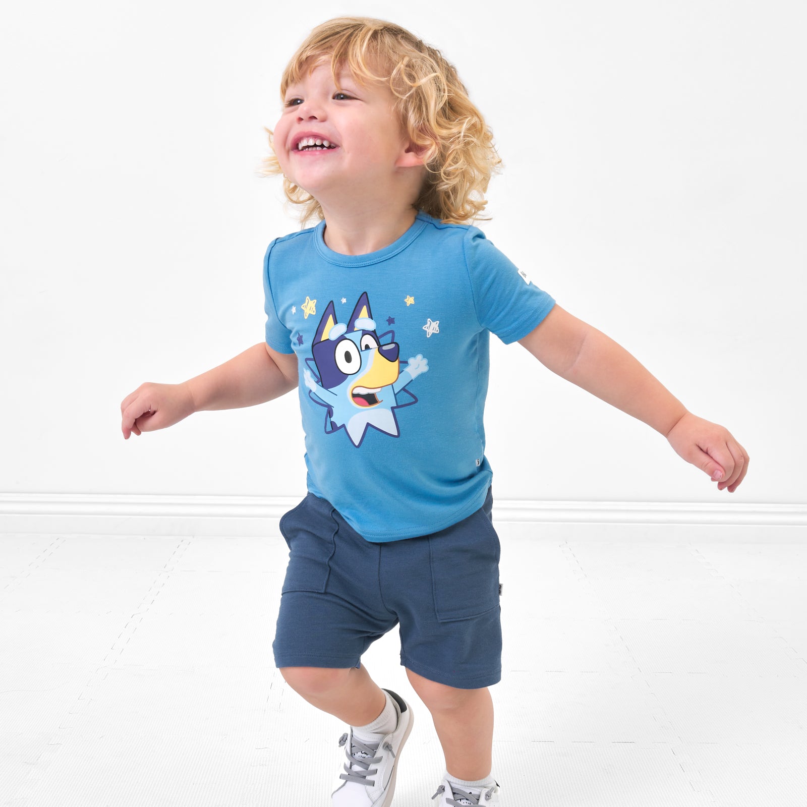 Child running wearing a Bluey graphic tee and coordinating shorts