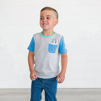 Boy standing while wearing the Bluey Graphic Pocket Tee