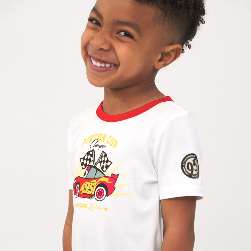 Alternate close up side view image of a child wearing a Lightning McQueen graphic tee