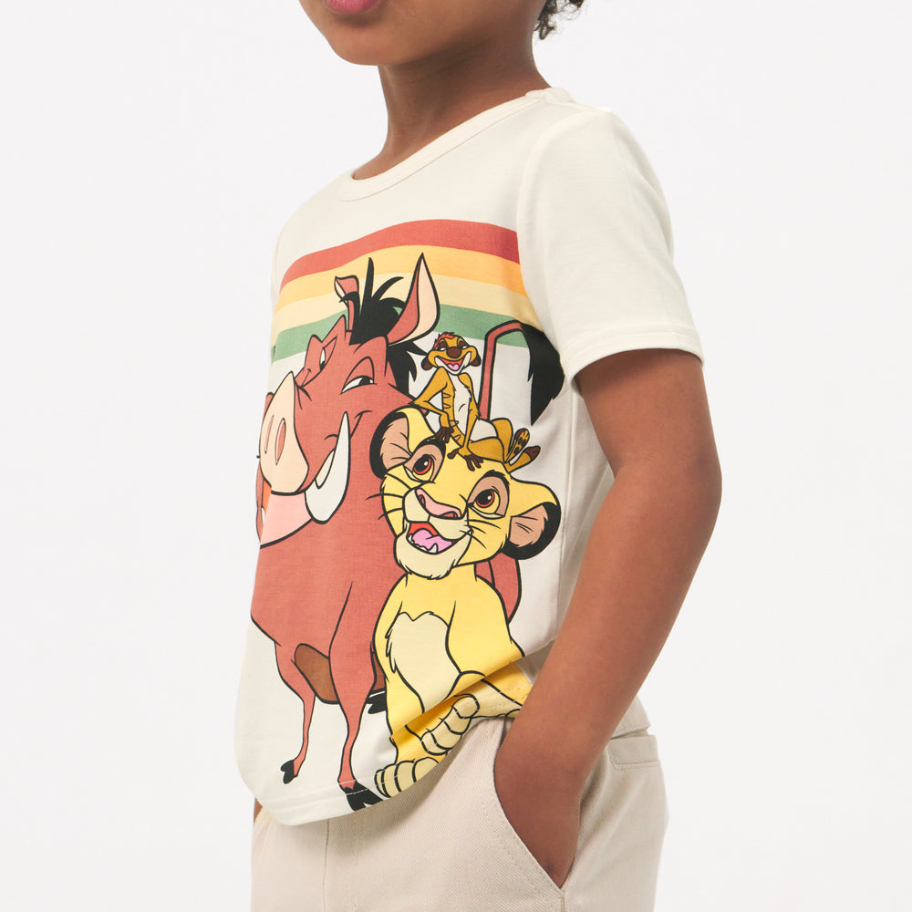 Close up side view image of a child wearing a Lion King graphic tee and coordinating Play shorts