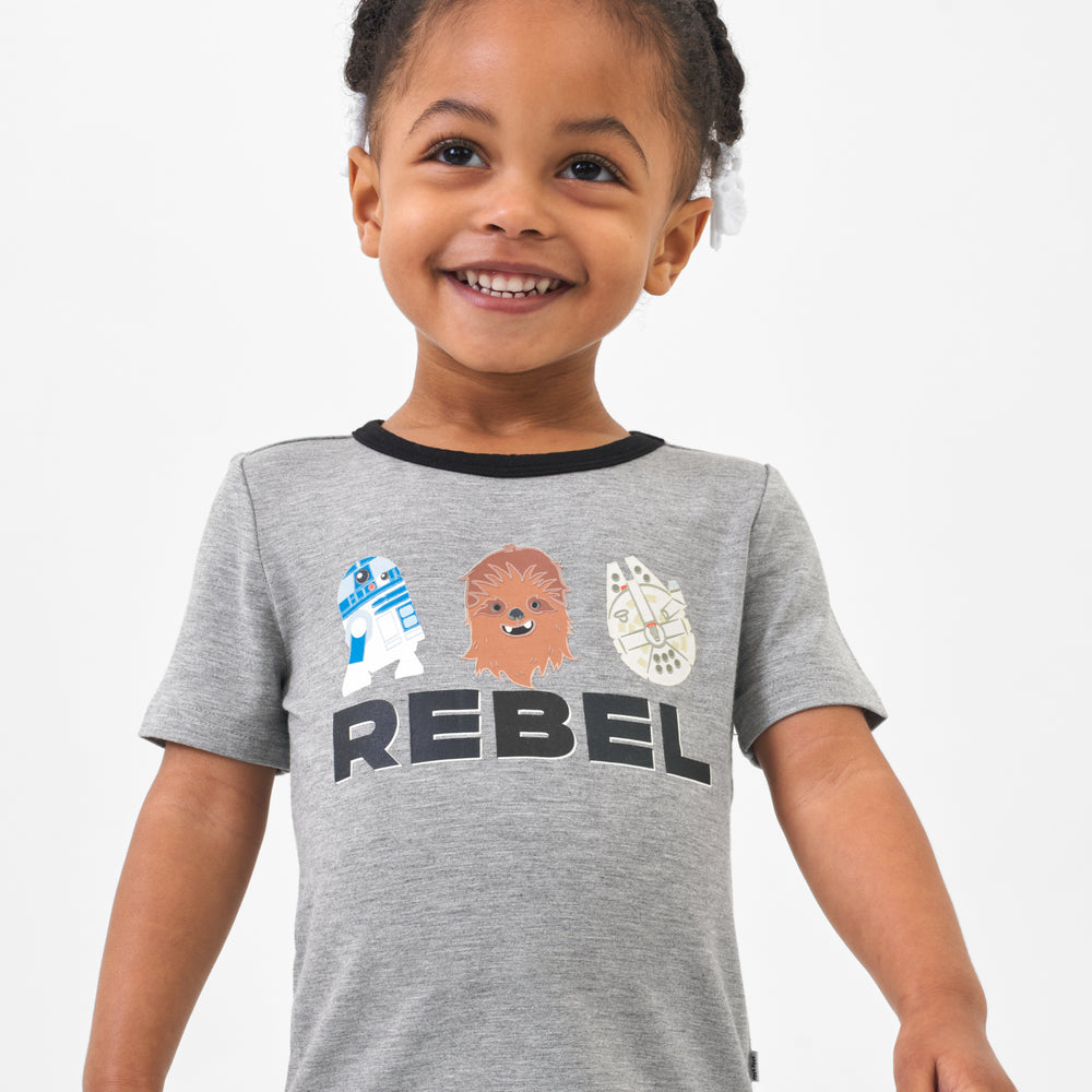 Close up image of a child wearing a Rebel graphic tee