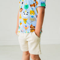 Profile view of a child wearing Blue Party Pals pocket tee paired with Bone shorts