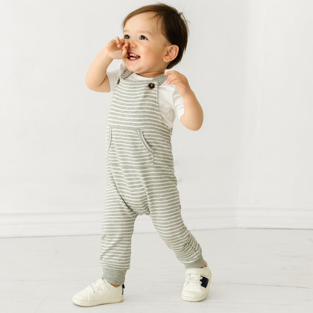 Child wearing Heather Gray Stripes overalls and coordinating Play bodysuit