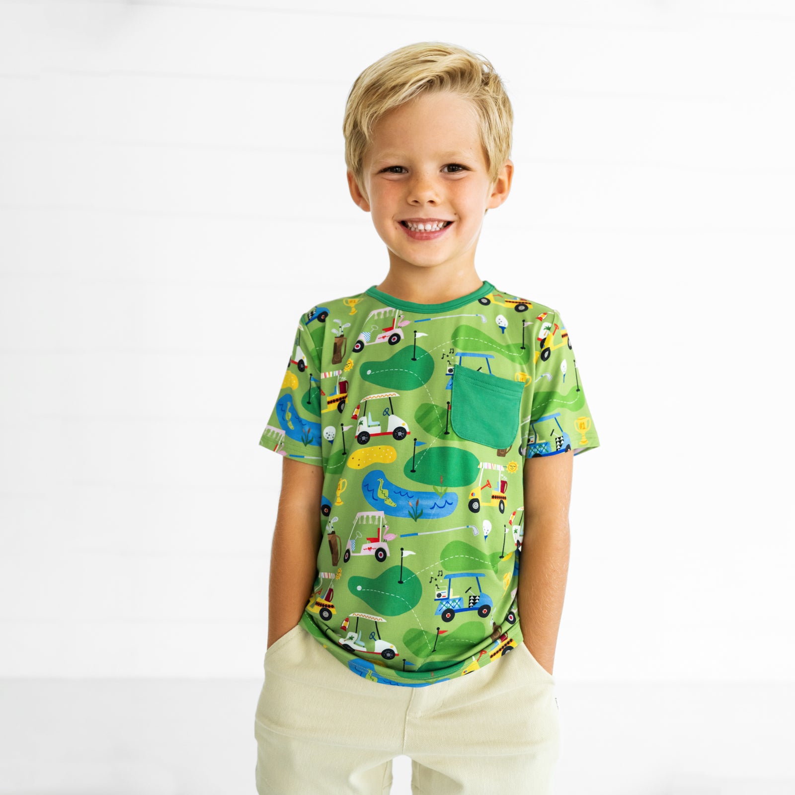 Close up image of a child wearing a Fairway Fun Pocket Tee and Light Khaki Chino Shorts