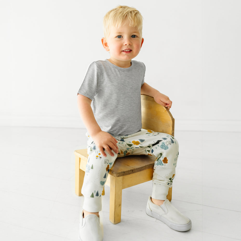 Child sitting on a stool wearing Let's Explore joggers and coordinating Play top