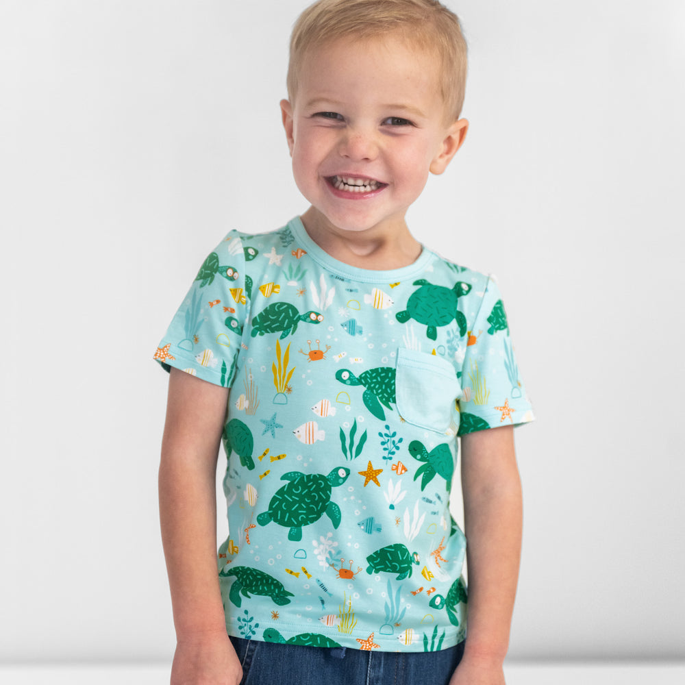 Close up image of a child wearing a Sea Turtle Friends Pocket Tee