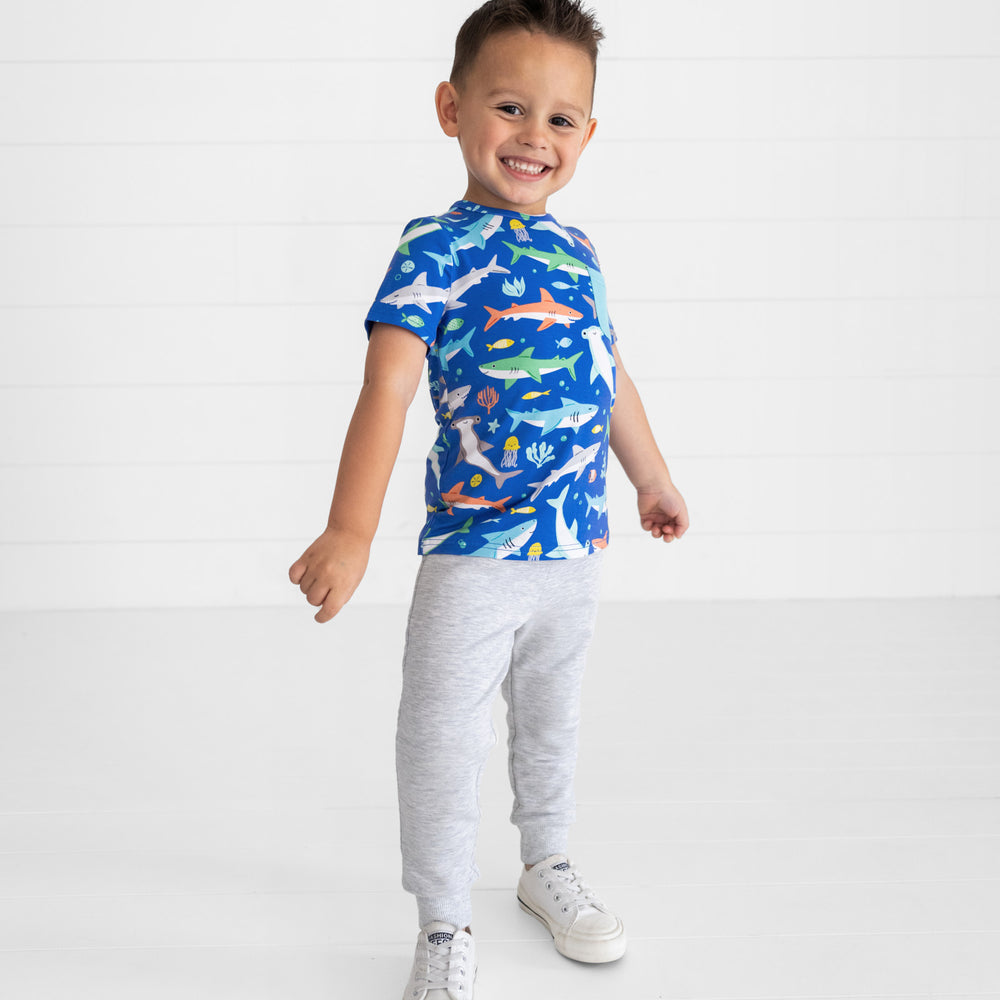 Smiling boy posing while wearing the Rad Reef Pocket Tee and Light Heather Gray Play Jogger