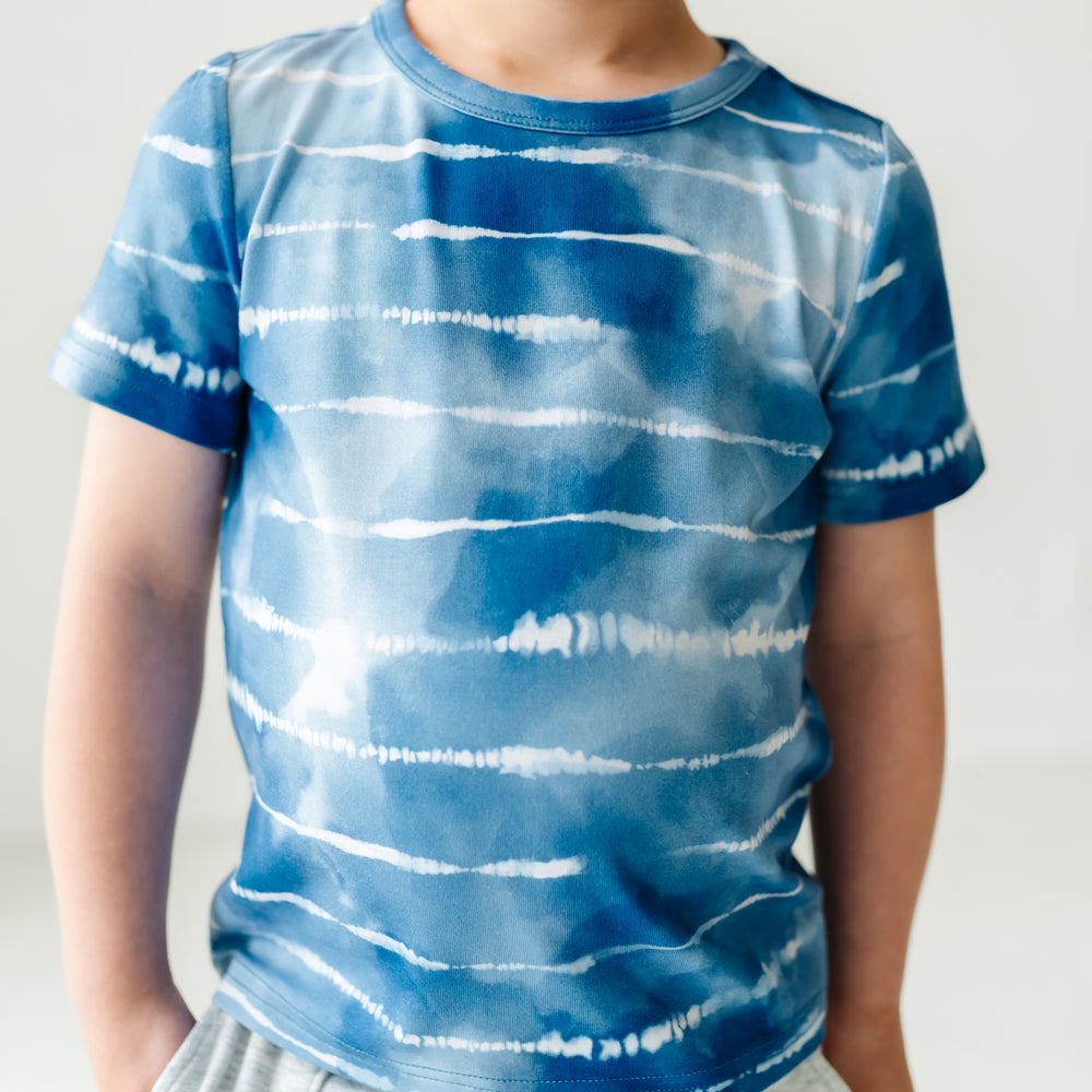 Close up image of a child wearing a Blue Tie Dye Dreams classic tee