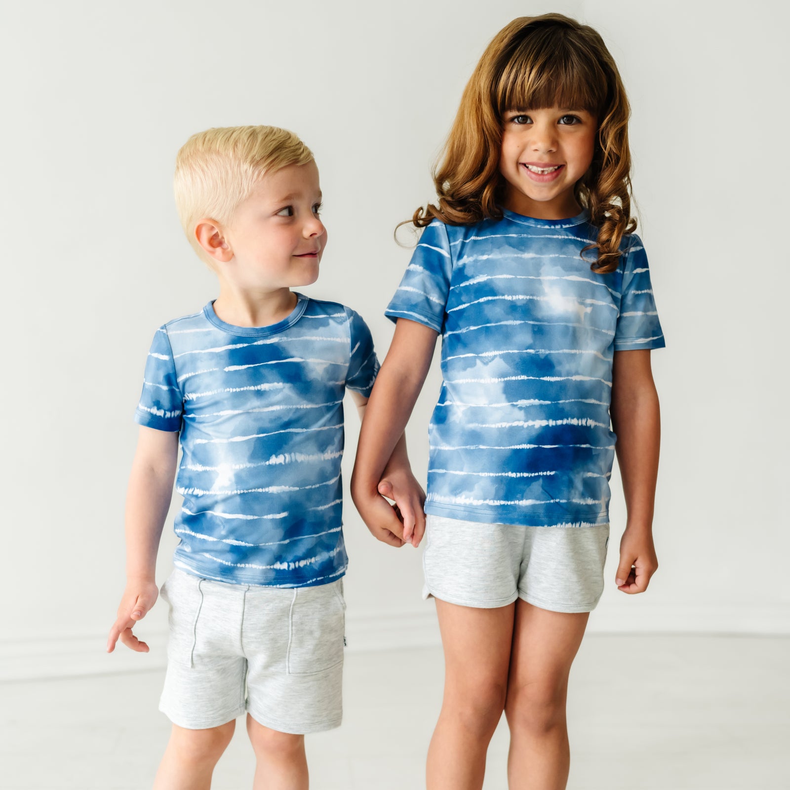 Two children wearing Blue Tie Dye Dreams classic tees with coordinating Play bottoms