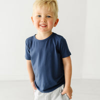 Close up image of a child wearing a Vintage Navy classic tee and coordinating Play jogger