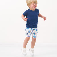 Child jumping wearing Seas the Day shorts paired with a Vintage Navy tee