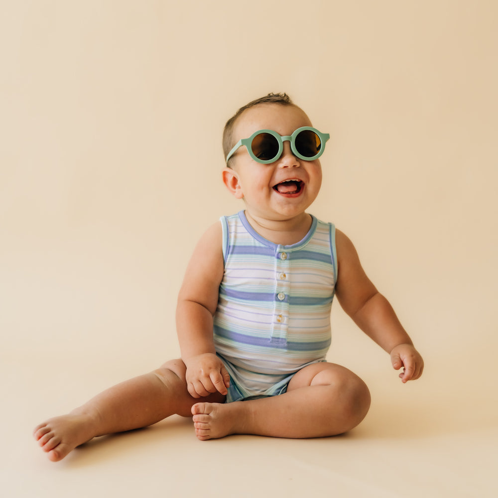 Alternate close up image of a child sitting wearing a Surf Stripe tank button romper