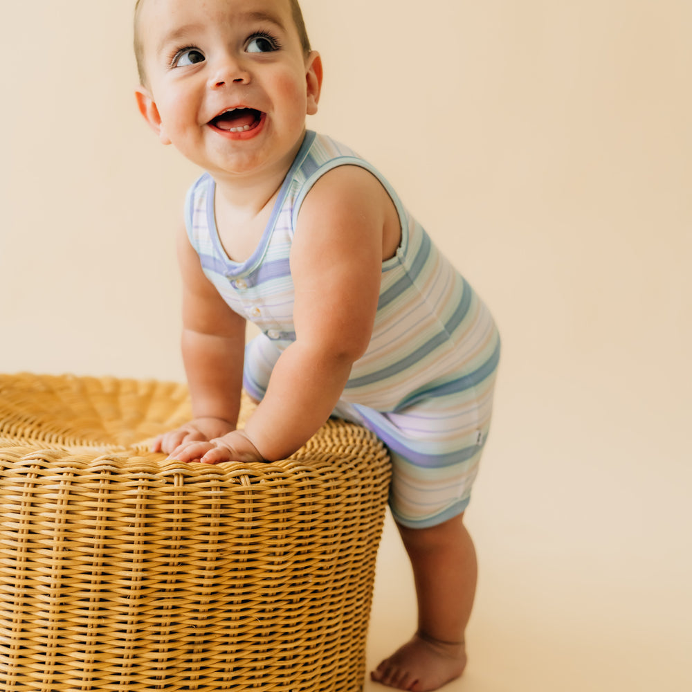 Child playing wearing a Surf Stripe button romper