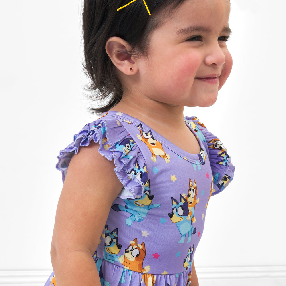 Close up image of a child wearing a Bluey flutter twirl dress with bodysuit