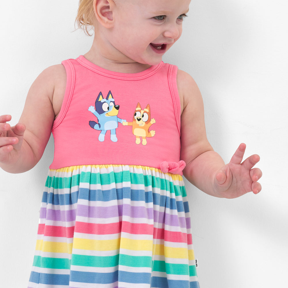 Close up image of a child wearing a Bluey graphic skater dress with bodysuit