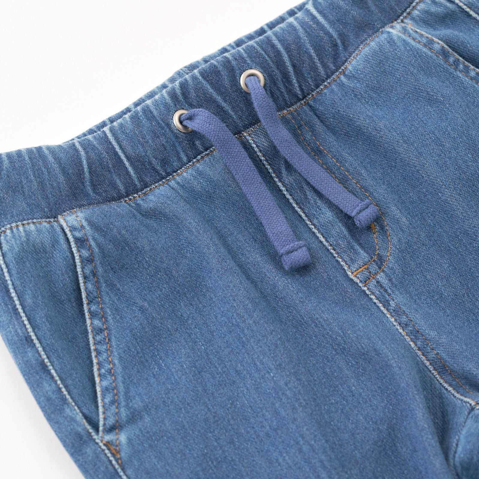 Close up flat lay image of the drawstring waist detail on the Midwash Blue Denim Jogger