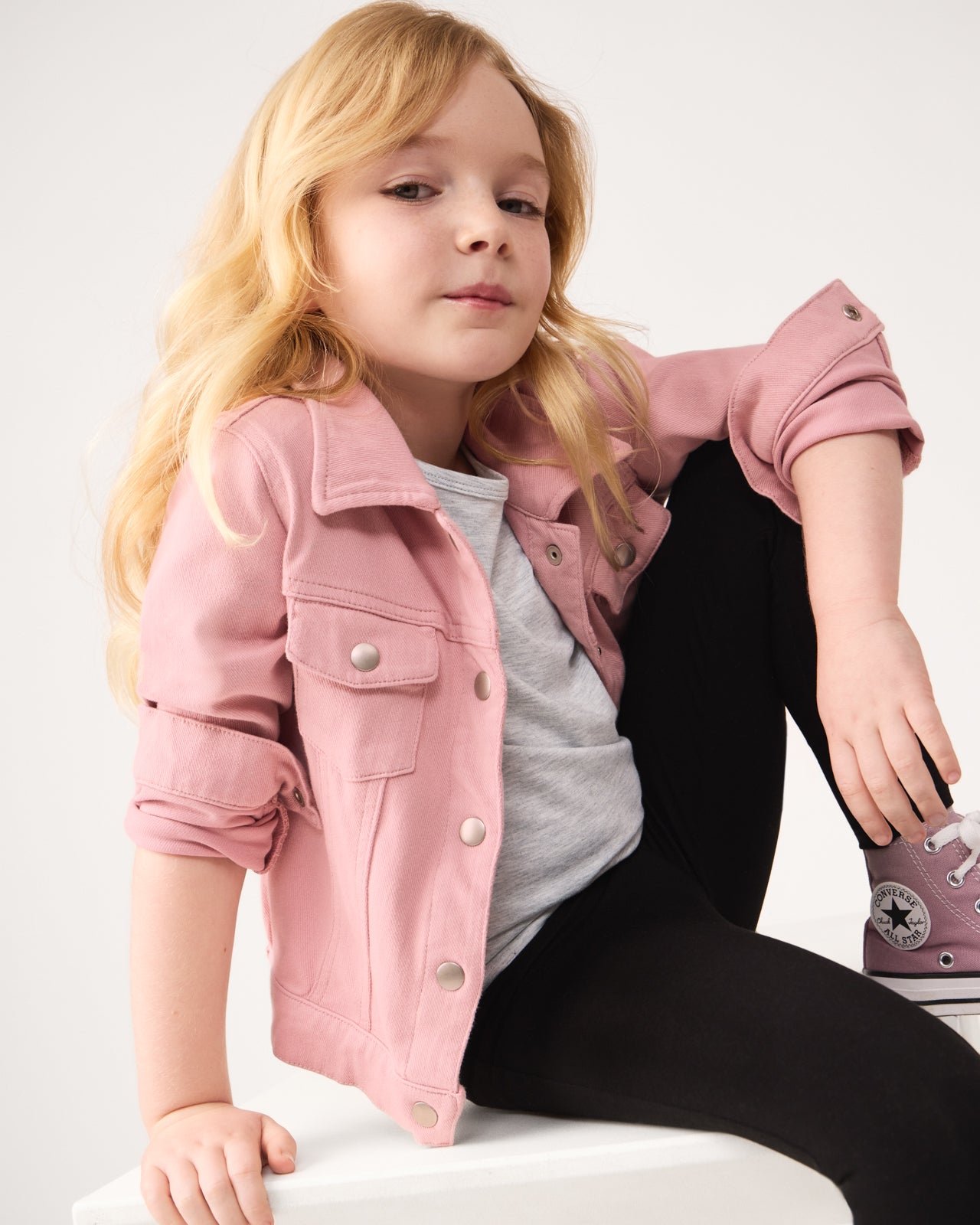 Girl wearing the Mauve Blush Denim Trucker Jacket with the sleeves rolled up