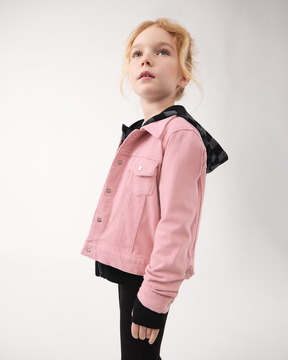 Girl wearing the Mauve Blush Denim Trucker Jacket over a black hoodie