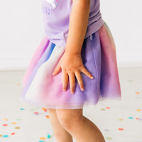 Alternate close up image of a child wearing a rainbow tutu skirt