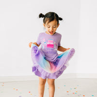 Child playing wearing a Magical Birthday Light Lavender graphic tee paired with a rainbow tutu skirt