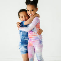 Two children hugging wearing coordinating Tie Dye Dreams pajamas