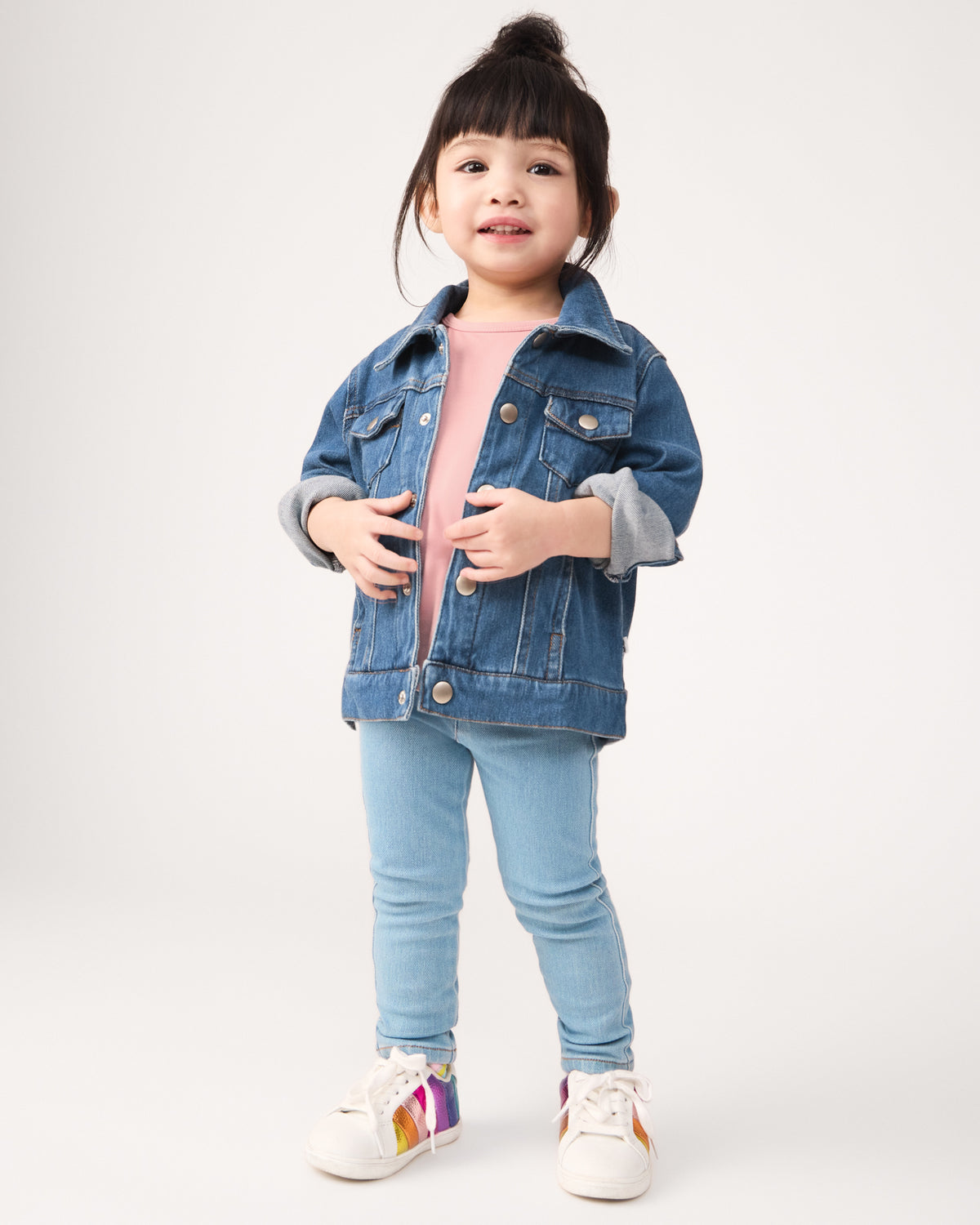 Girl wearing the Midwash Blue Denim Trucker Jacket with light wash denim jeggings