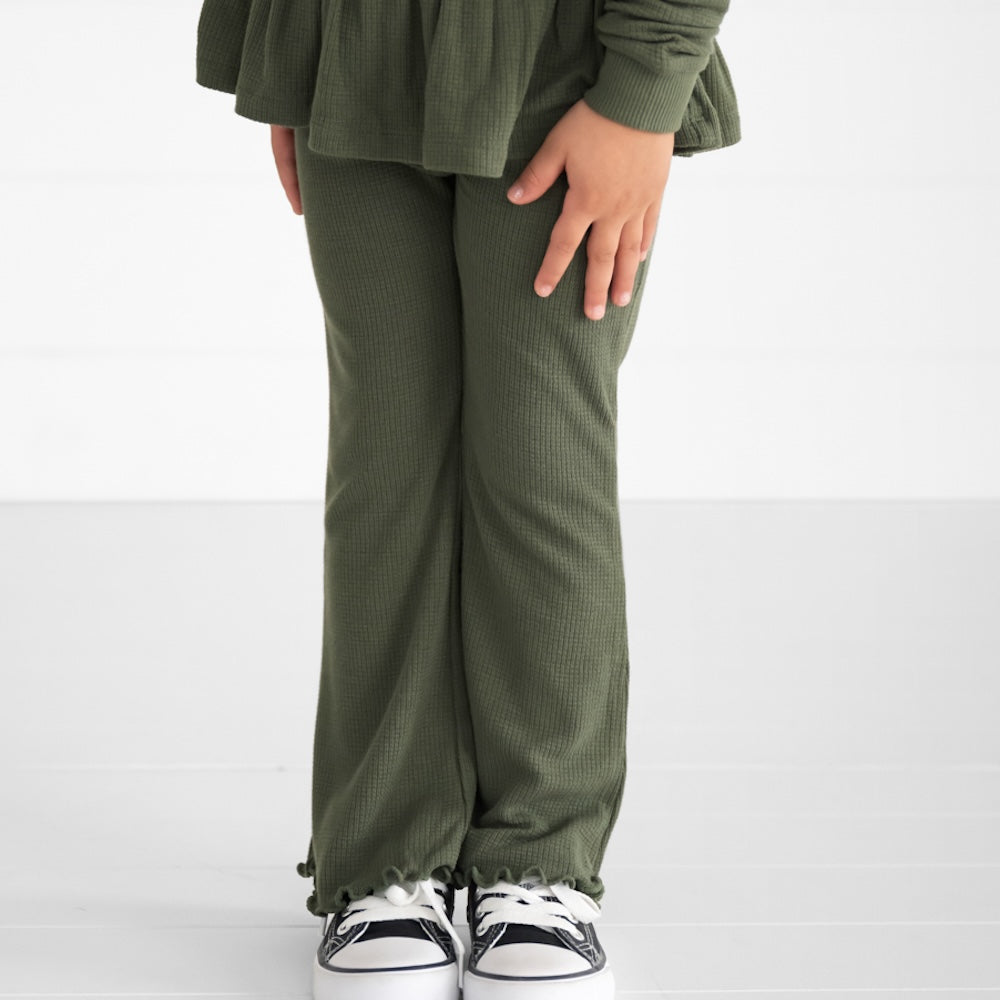 Close up image of a child wearing an Olive Waffle Flare Pant