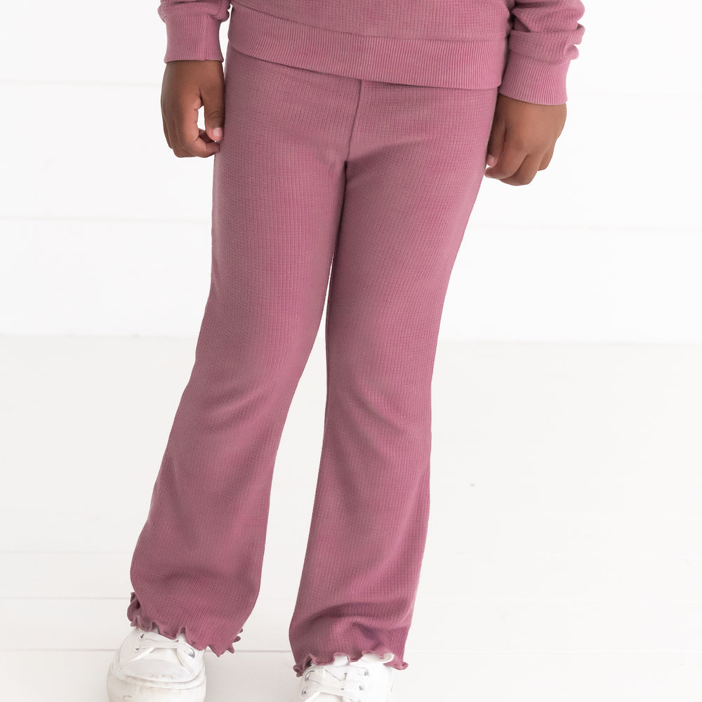 Close up image of a child wearing a Dusty Plum Waffle Flare Pant and matching Crewneck