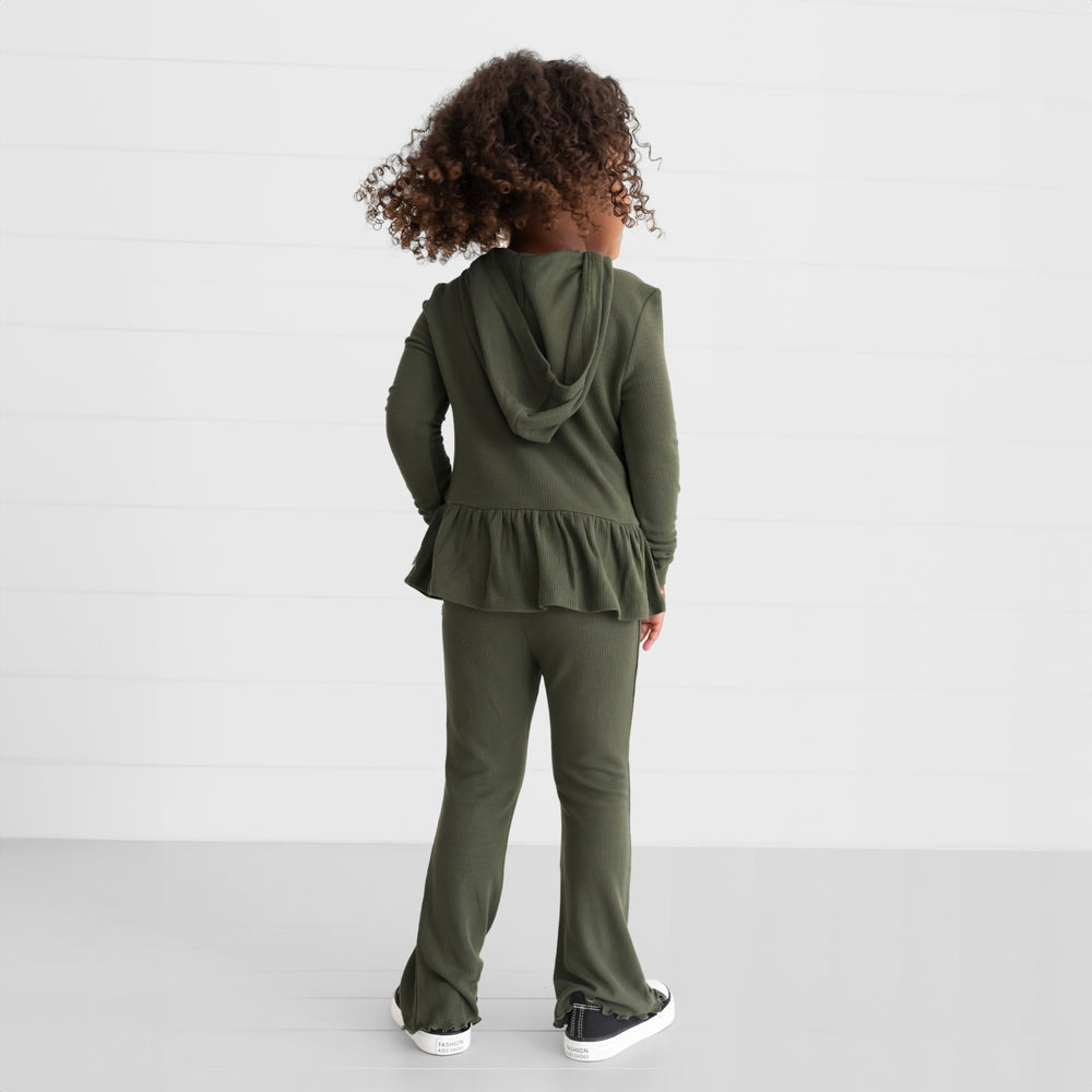 Back view image of a child wearing an Olive Waffle Peplum Hooded Tee and Flare Pants