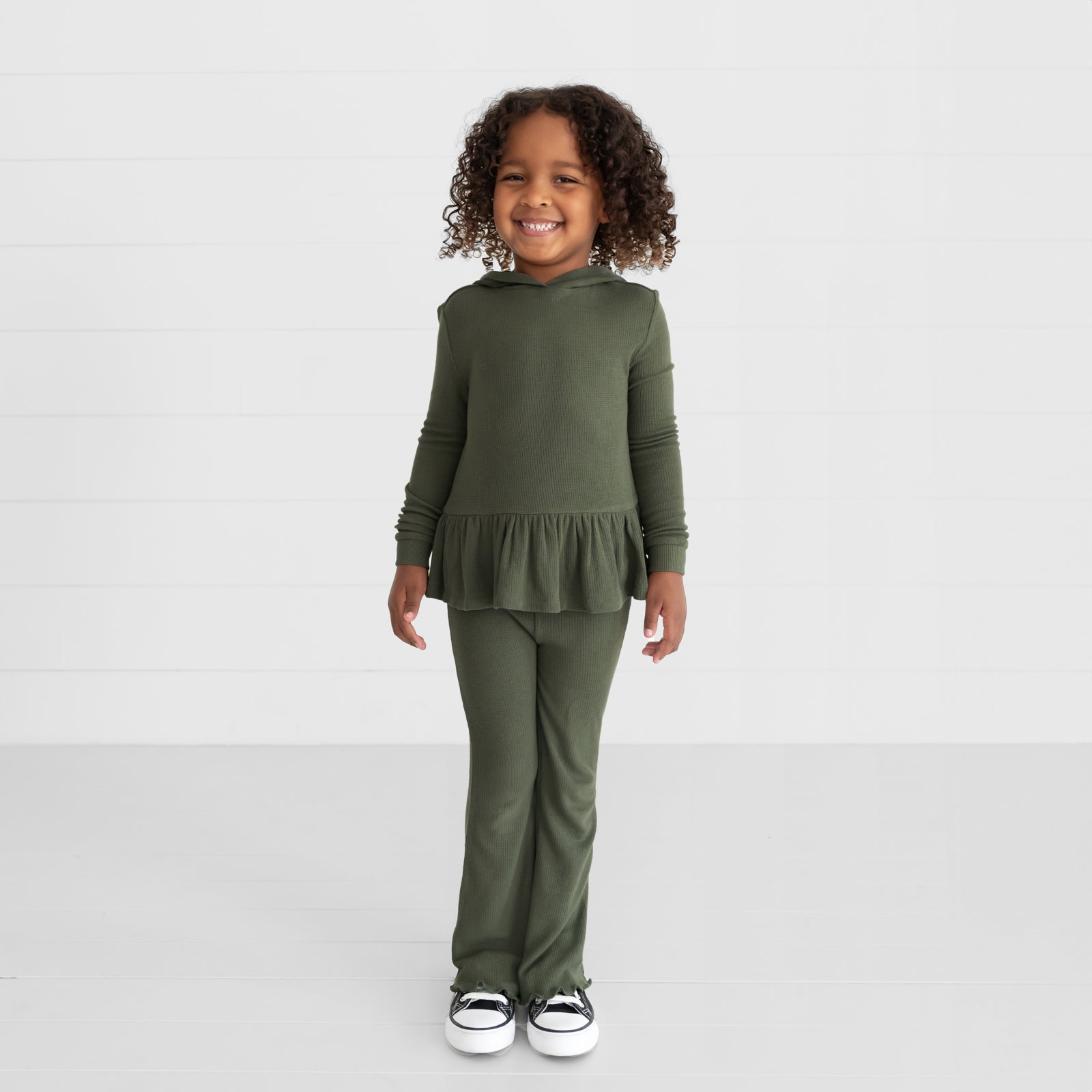 Image of a child wearing an Olive Waffle Flare Pant and Peplum Hooded Tee