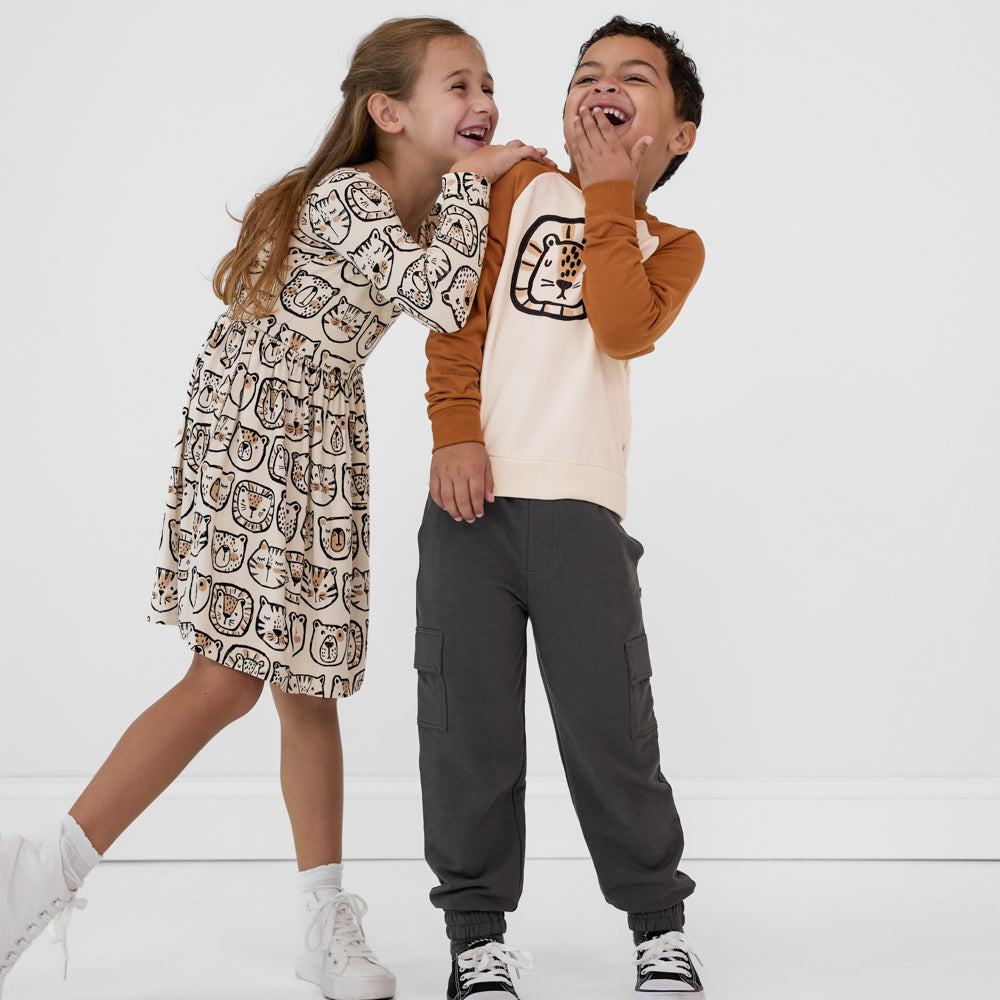 Two children wearing coordinating Lions, Tigers & Bears outfits