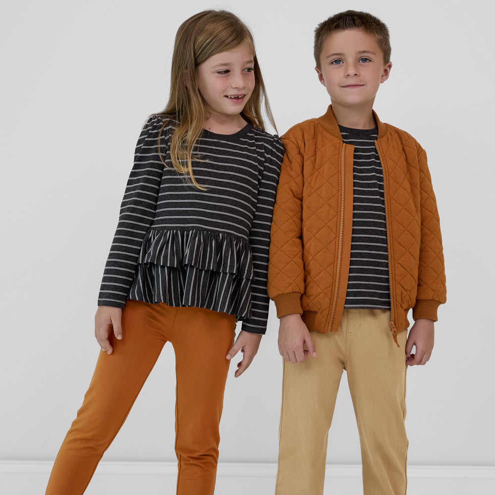 Two children wearing coordinating Heather Black Stripes and Golden Brown outfits