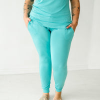 Close up image of a woman wearing Glacier Turquoise women's pajama pants
