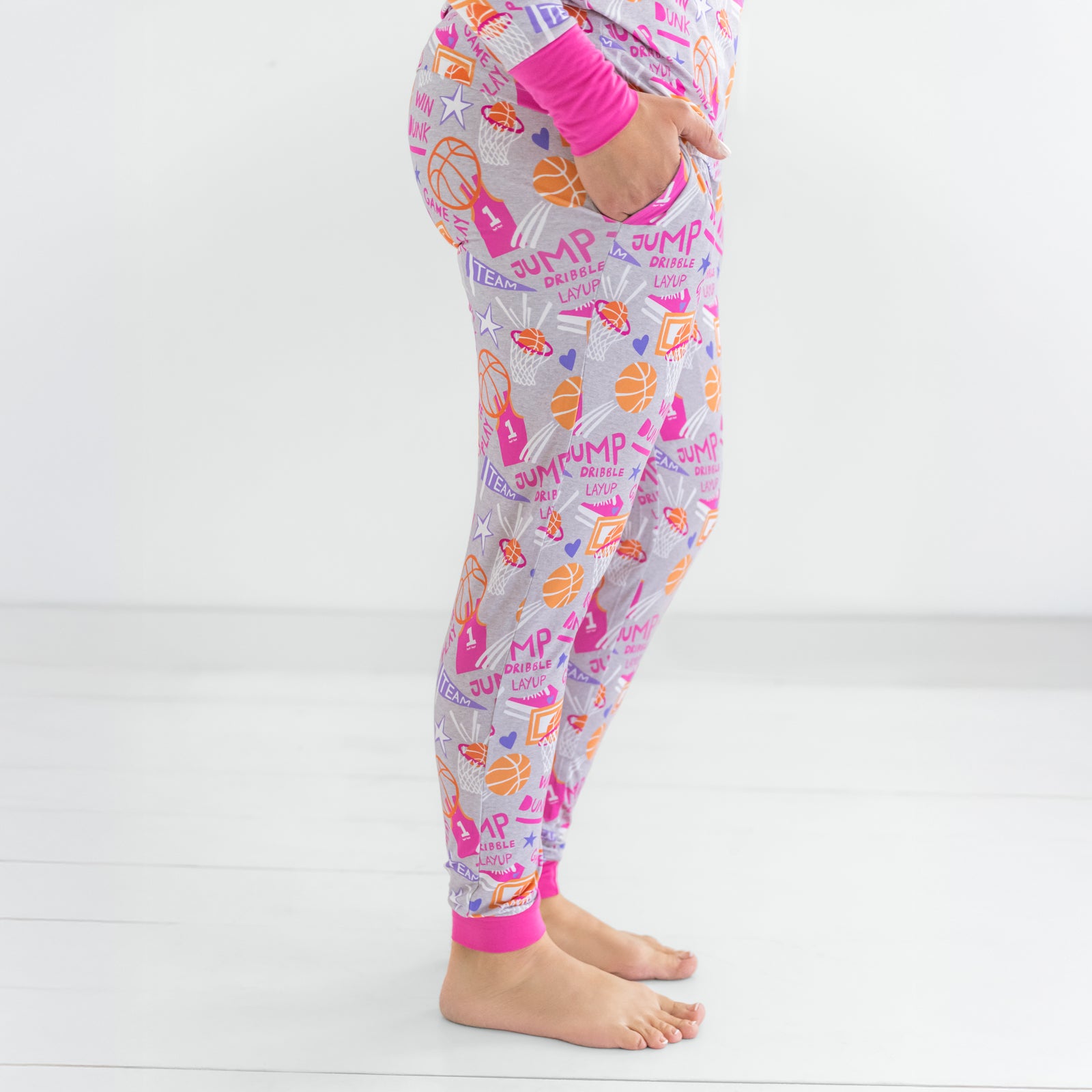 Side view of woman standing in the Pink Slam Dunk pajama pants