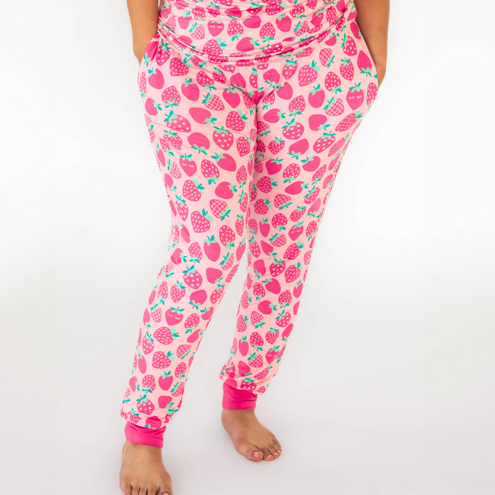 Woman wearing the Sweet Strawberries Women's Pajama Pants, displaying pockets