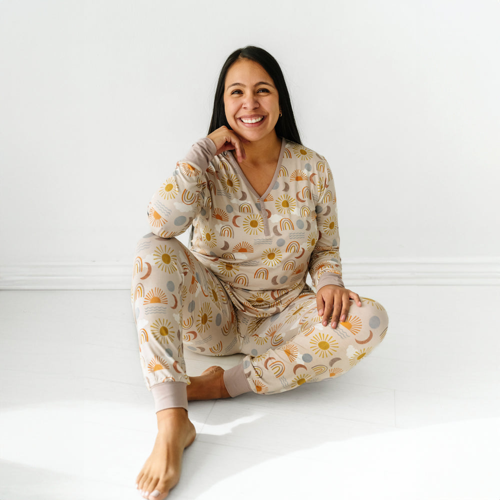 Click to see full screen - Woman sitting wearing a Desert Sunrise women's pajama top paired with matching women's pajama pants