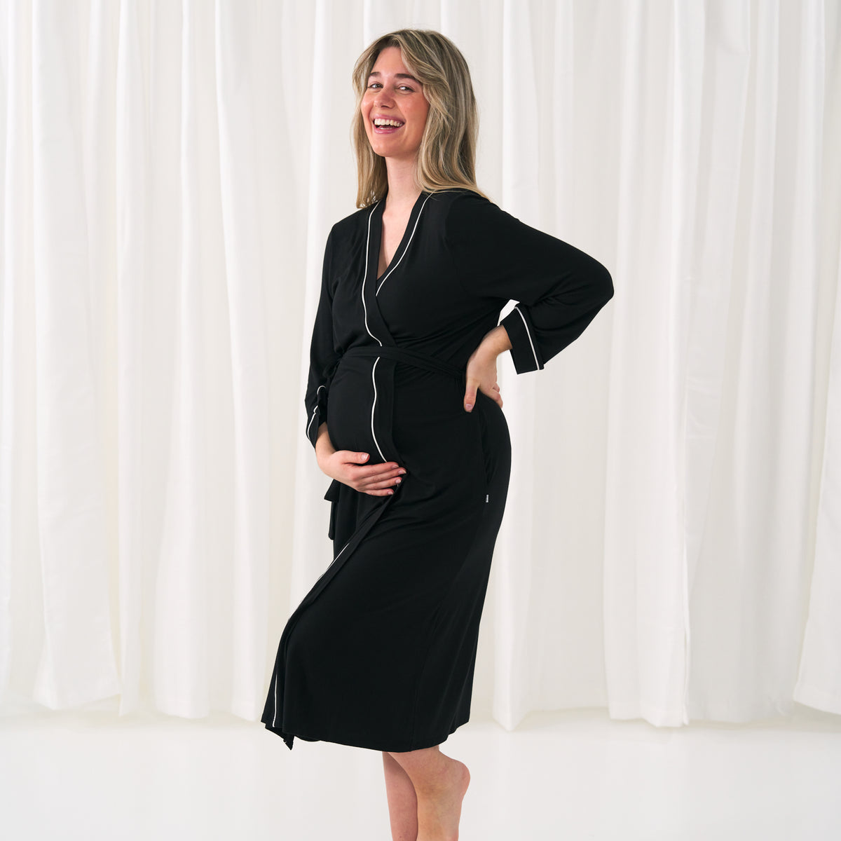 woman holding her baby bump wearing a women's black robe