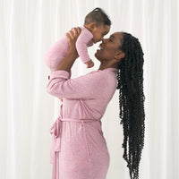 Woman wearing a Heather Mauve women's robe holding up her child matching in a Heather Mauve zippy