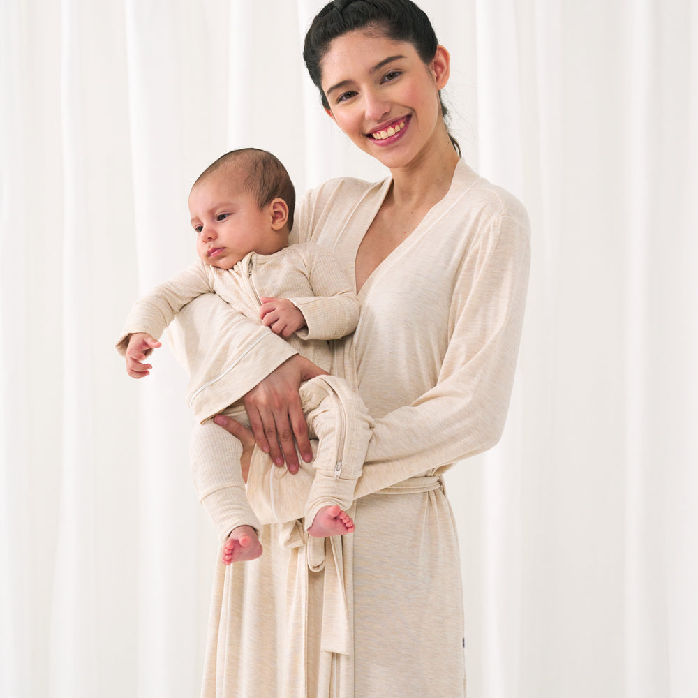 Woman posing with her child wearing a Heather Oatmeal women's robe. Her child is matching wearing a Heather Oatmeal zippy.