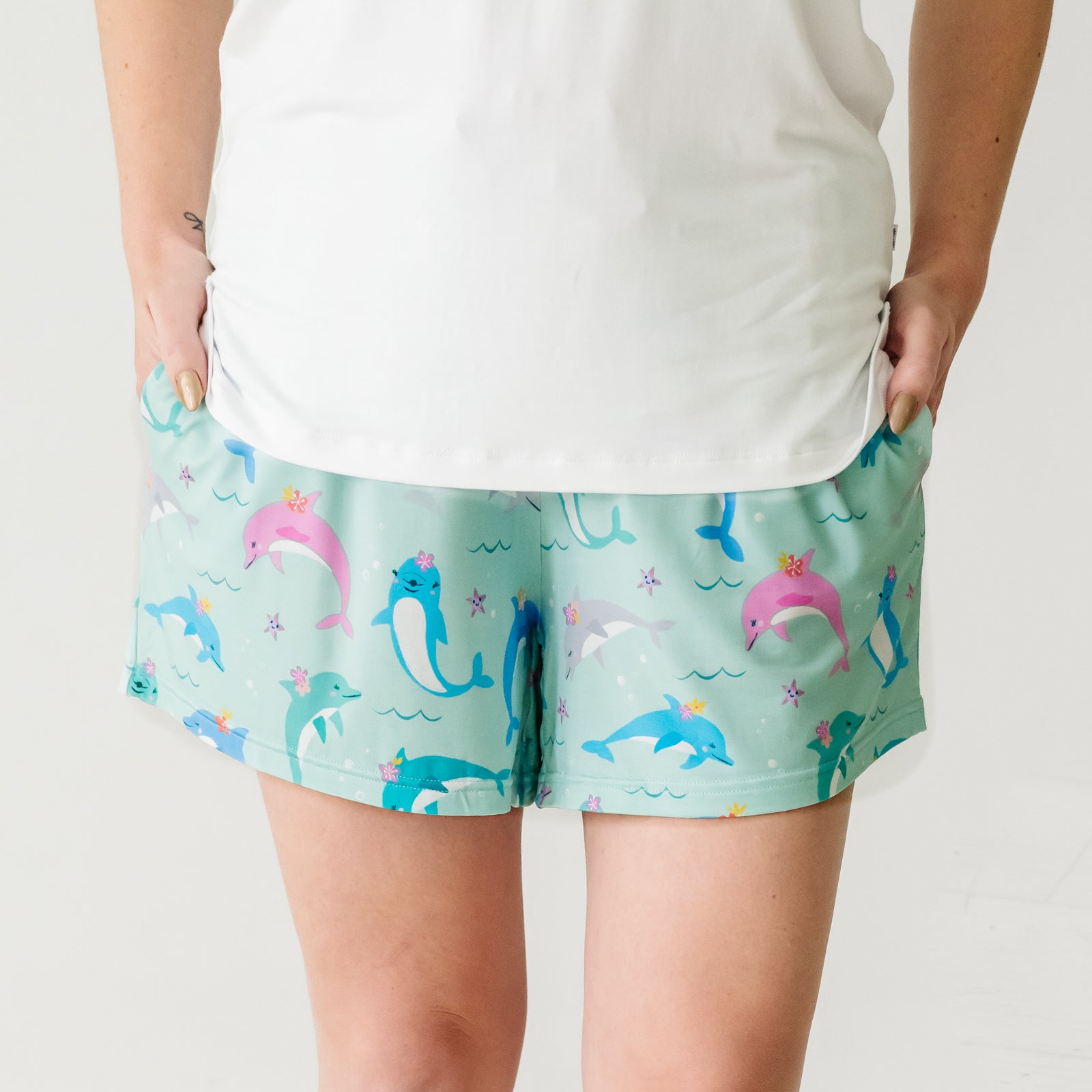 Close up image of a woman wearing Dolphin Dance women's pajama shorts and coordinating top