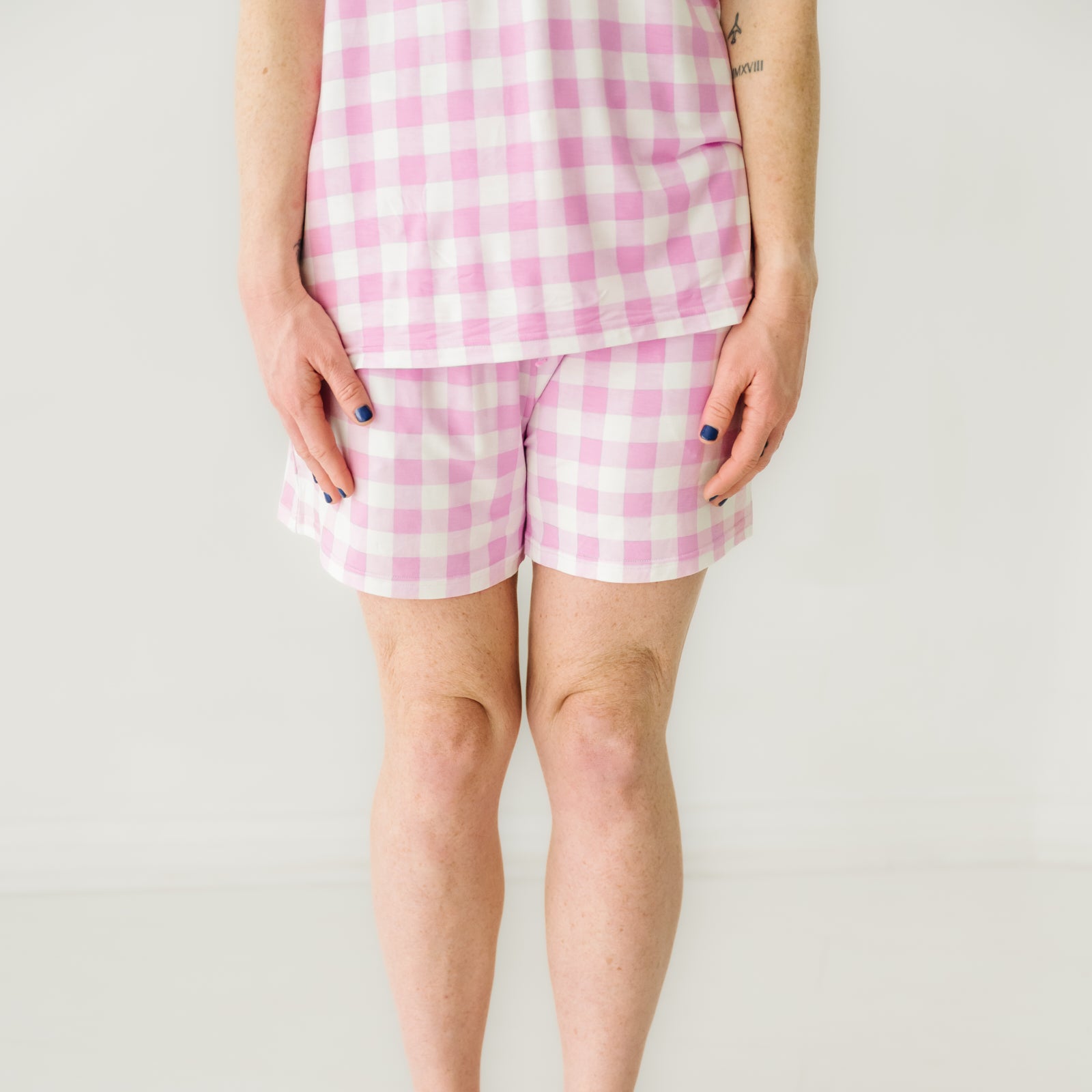 Close up image of a woman wearing Pink Gingham pajama shorts