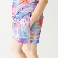 Close up side view image of a woman wearing Pastel Tie Dye Dreams women's pajama shorts and matching pajama top