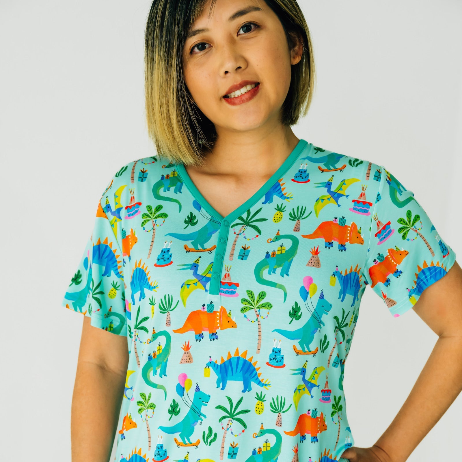 Close up image of a woman wearing a Prehistoric Party pj top