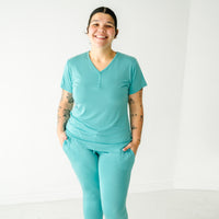 Image of a woman wearing a Glacier Turquoise women's short sleeve pajama top and matching women's pajama pants