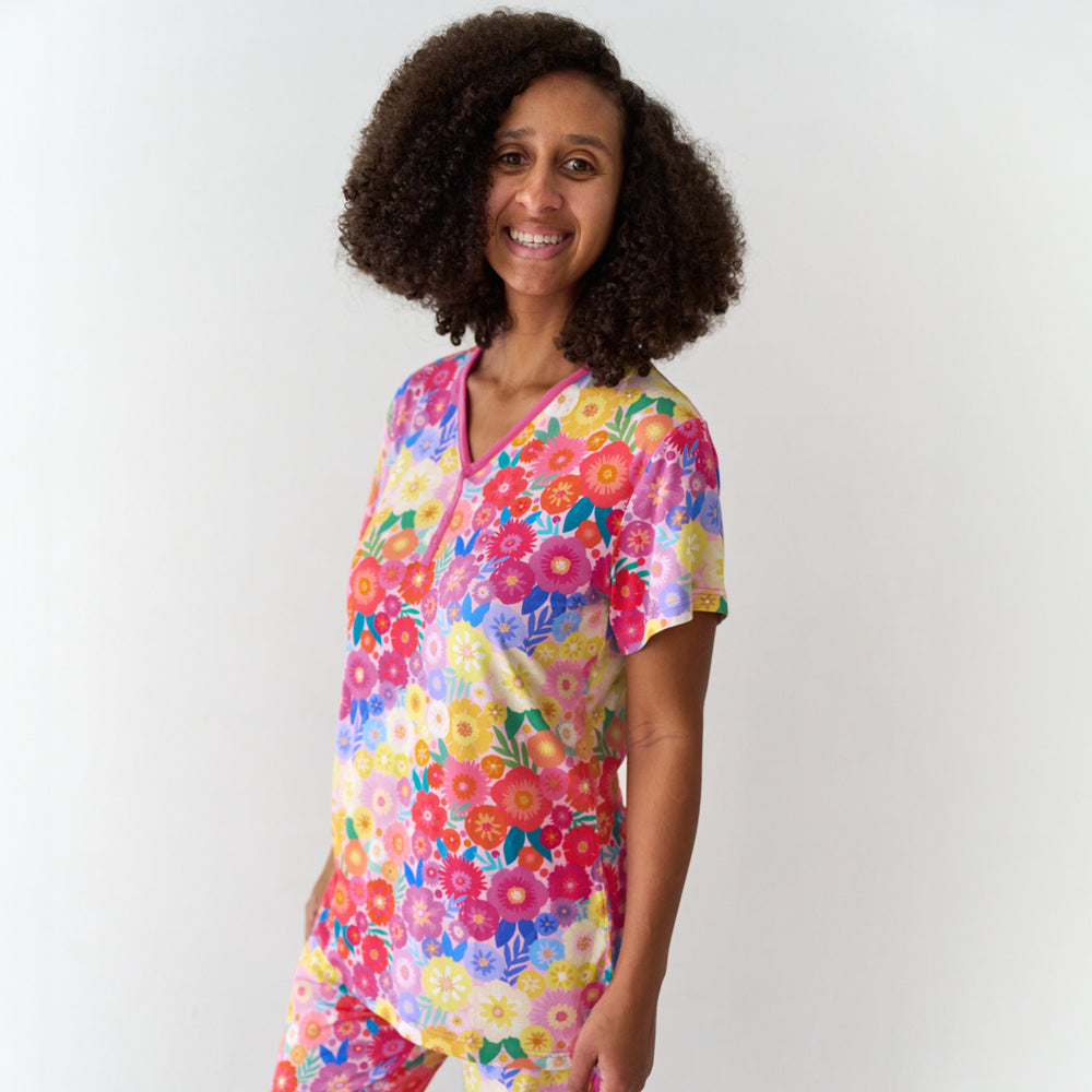 Woman wearing Rainbow Blooms women's short sleeve pajama top and matching pajama pants