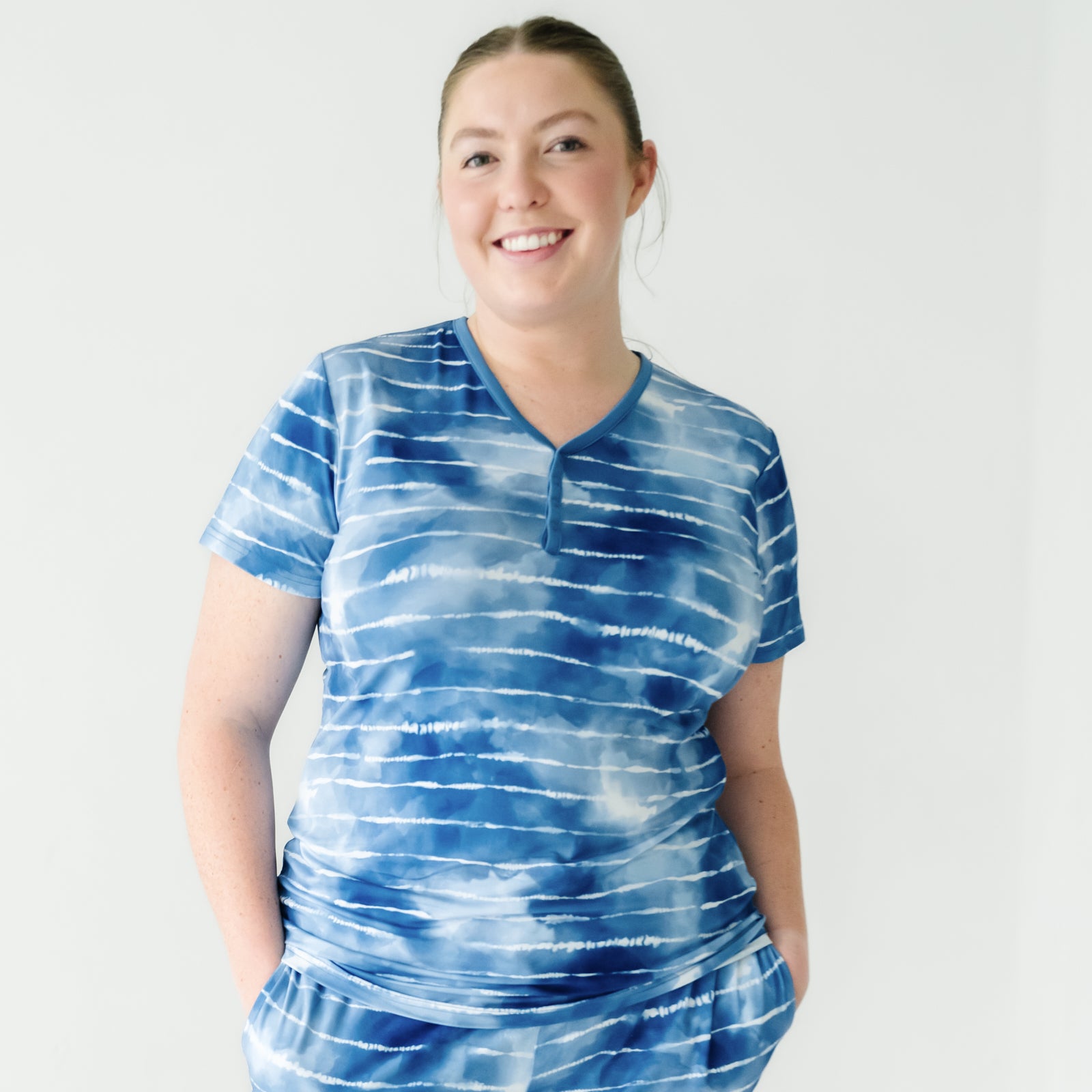 Close up image of a woman wearing a Blue Tie Dye Dreams women's short sleeve pajama top and matching pajama shorts
